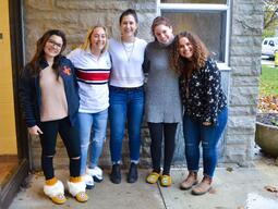 A group of indigenous undergraduate nursing students standing together, arms over each others shoulders and smiling at the camera